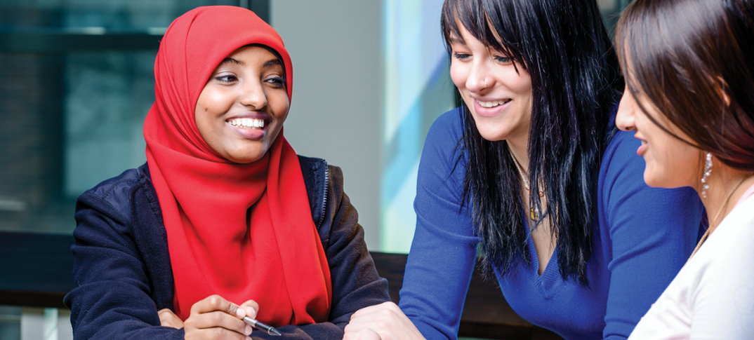 Three students smiling and talking